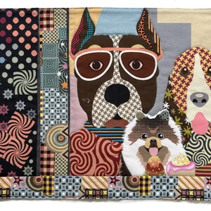 以下が含まれることがあります： サングラスをかけた3匹の犬が描かれた、カラフルな布製アート作品。犬はブルドッグ、スパニエル、ポメラニアンです。背景には、さまざまな色の幾何学模様と渦巻き模様があります。