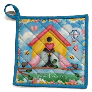 May include: A square, quilted pot holder with a blue border and hanging loop. The design features a yellow birdhouse with a red roof, two birds, butterflies, bees, and the words "love birds".