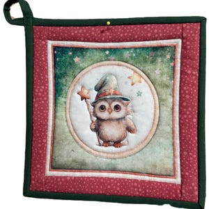 Può includere: Presina quadrata trapuntata con un gufo con cappello da mago e bacchetta a stella. Il disegno è racchiuso in una cornice circolare su uno sfondo verde e bianco stellato. Ha un bordo rosso a pois bianchi, un bordo verde e un anello per appenderla. Circa 20 cm quadrati.