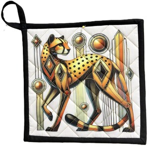Könnte beinhalten: Ein quadratischer, gesteppter Topflappen mit einer stilisierten Geparden-Illustration in Orange-, Gelb- und Schwarztönen. Das Design zeigt geometrische Formen und kreisförmige Motive auf weißem Grund mit schwarzer Stoffeinfassung und Aufhängeschlaufe.