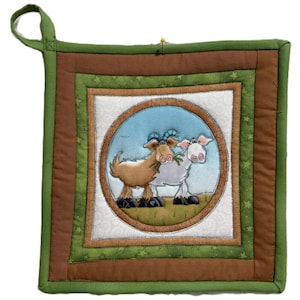 May include: Square quilted pot holder with a loop for hanging. The center features a blue circle with two cartoon goats. The pot holder has brown, green, and white patterned borders. The outer border is green with star patterns.