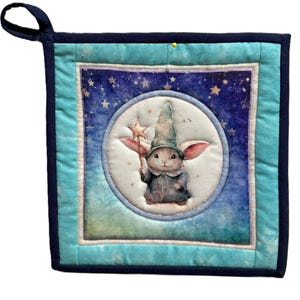 Può includere: Un sottopentola quadrato e trapuntato con un design stravagante. Il centro presenta un coniglio vestito da mago che tiene una bacchetta a stella, su uno sfondo di cielo stellato. Il sottopentola ha un bordo turchese e un bordo blu navy, con un anello per appenderlo.