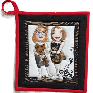 May include: Square quilted potholder with a red border and hanging loop. The center features a whimsical illustration of two women in dresses and heels. The background has a zebra print and black border.