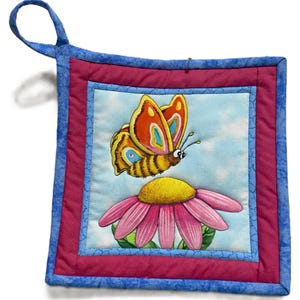 May include: A pink and yellow flower with a butterfly on it. The butterfly has orange, yellow, and blue wings. The pot holder is blue and pink with a white background.