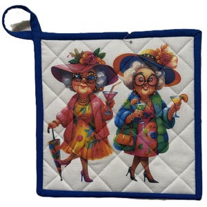 May include: Quilted pot holder with a blue border and hanging loop. The center features a colorful illustration of two elderly women in hats, holding cocktails. The women are dressed in vibrant outfits and accessories.