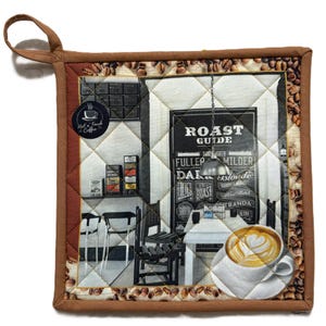 May include: Square quilted pot holder with a brown border and a hanging loop. The centre features a black and white image of a coffee shop with a "Roast Guide" sign and a latte art coffee cup. The border is decorated with coffee beans.