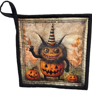 May include: Halloween-themed quilted pot holder featuring a whimsical pumpkin-headed creature with a striped hat, set against a backdrop of autumn leaves and pumpkins. The pot holder has a black border and a loop for hanging.
