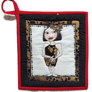 May include: Square quilted potholder with a red border and a loop for hanging. The center features a hand-drawn illustration of a woman in a black dress with gold floral accents and a leopard print bow. The potholder has a black and leopard print border.