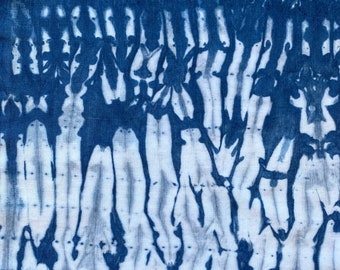 May include: Abstract blue and white tie-dye pattern on fabric. The pattern resembles a series of vertical lines with a mottled, faded effect.