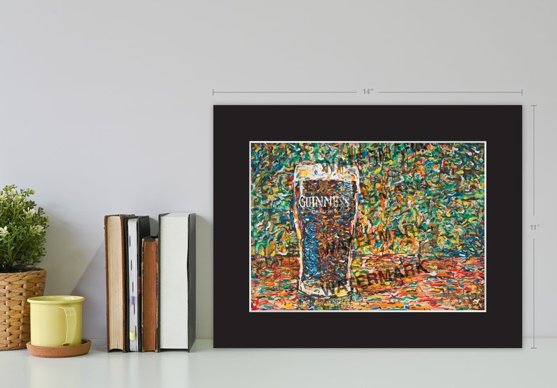 May include: A framed print of a painting depicting a glass of Guinness beer on a colorful background. The painting is made up of small, colorful brushstrokes. The glass of Guinness is in focus, and the background is blurred. The print is 14 inches wide and 11 inches tall.