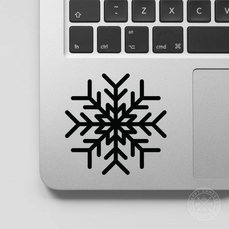 May include: Black snowflake sticker on a silver laptop.