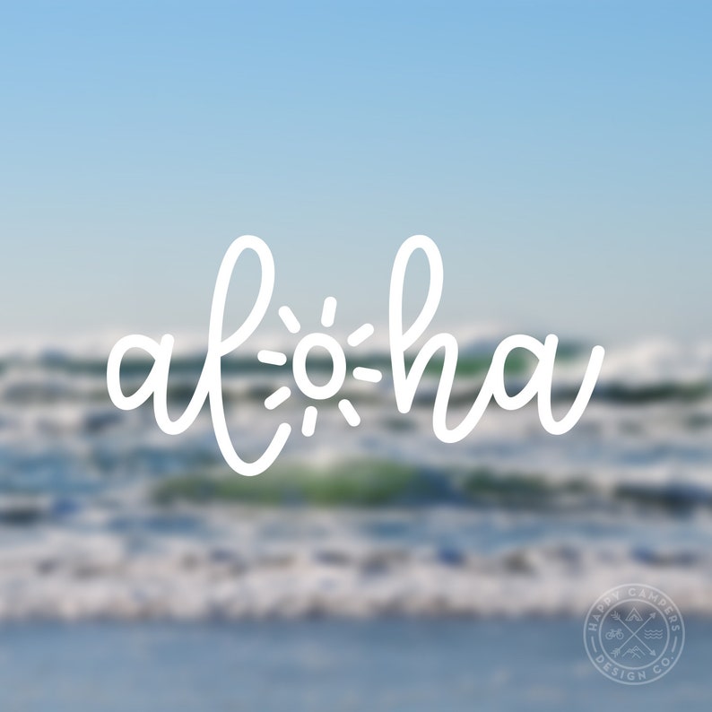 May include: White text that says "Aloha" with a sun graphic in the middle of the word. The background is a blurry image of the ocean.