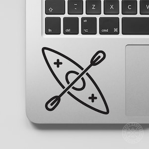 Puede incluir: Adhesivo en blanco y negro con un dise&ntilde;o de kayak y remo. El kayak tiene dos signos m&aacute;s a los lados y un c&iacute;rculo en el medio. El remo est&aacute; colocado en diagonal sobre el kayak.