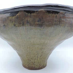 May include: A set of three ceramic mugs with a speckled, matte finish. The mugs are in shades of cream, light gray, and dark gray. Each mug has a simple, minimalist design and a rounded handle. Perfect for coffee or tea.