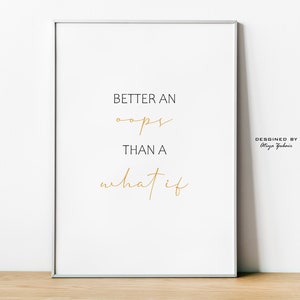 May include: A white framed print with the text "Better an oops than a what if" in black and gold lettering. The text "Designed by Olga Furman" is in black lettering at the bottom right corner of the print.