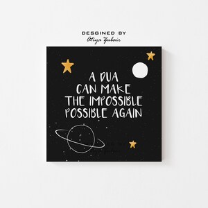 May include: A black square print with white text that reads "A DUA CAN MAKE THE IMPOSSIBLE POSSIBLE AGAIN." The print features a white planet with rings, gold stars, and the words "Designed by Atiya Zubair."