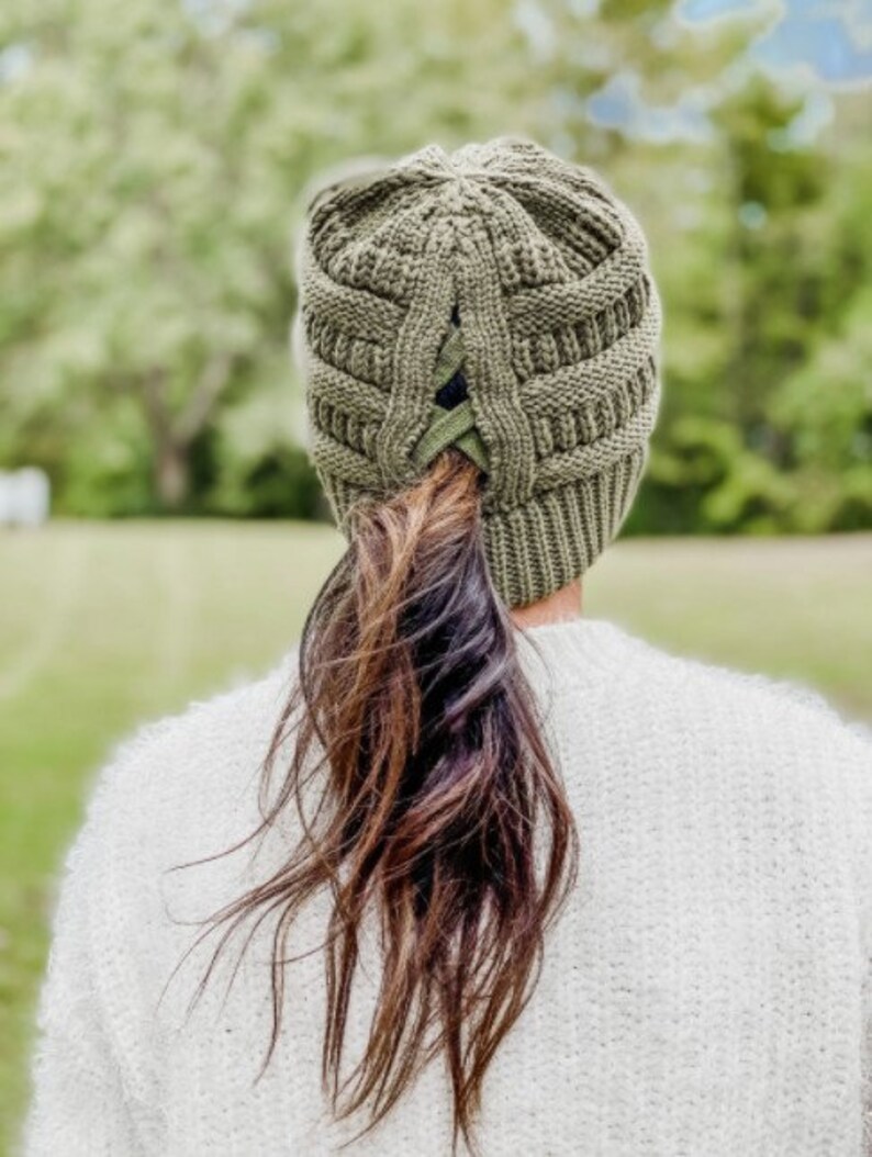 May include: A green knit beanie with a built-in ponytail holder. The beanie is made of a soft, warm material and is perfect for keeping your head and ears warm in the cold weather.