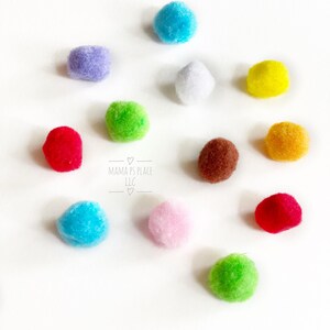 May include: A collection of 10 colorful pom-poms in various colors, including red, blue, green, yellow, purple, pink, white, and brown. The pom-poms are arranged on a white surface.