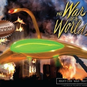 May include: A model kit box for "The War of the Worlds" featuring a Martian War Machine. The box art shows a gold and green spacecraft with a red head, flying over a city engulfed in flames. The words "Special Edition Plated" are visible.