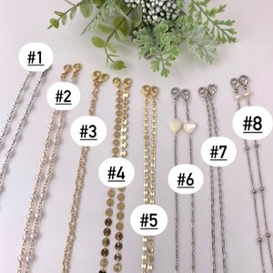 May include: Eight different styles of gold and silver chains with various charms and beads. The chains are numbered 1 through 8.