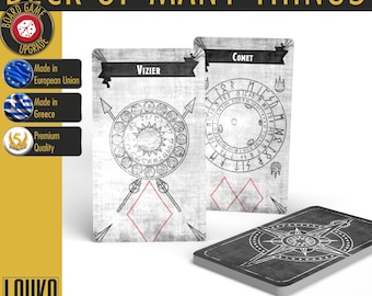 May include: A Deck of Many Things card set featuring three rectangular cards with a gray textured background. Two cards are upright, labeled Vizier and Comet, displaying circular symbols and runes. The third card lies flat, showing a compass design.