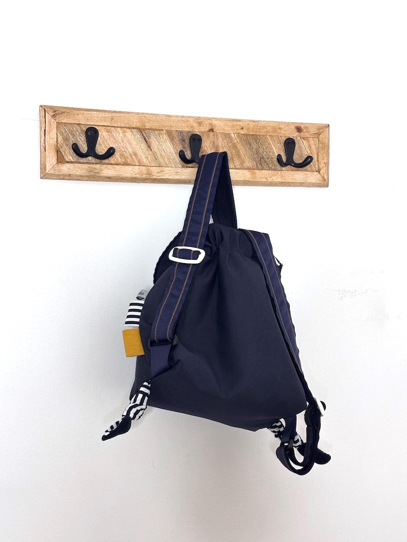 Les bretelles du sac à dos sont réglables par l’intermédiaire de boucles coulissantes, afin de s’adapter parfaitement à l’enfant. Le verso des bretelles est en polaire marine, ce qui les rend confortables et agréables à porter pour le tout-petit.