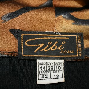 K&ouml;nnte beinhalten: Ein schwarzes Etikett mit dem Text "Tibi Roma" und "Made in Italy". Ein kleineres wei&szlig;es Etikett mit Gr&ouml;&szlig;enumrechnungen in italienischer, franz&ouml;sischer, britischer und amerikanischer Gr&ouml;&szlig;e.