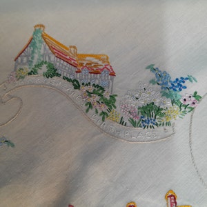 May include: Embroidered white linen tablecloth with a colorful floral design and the text "Shakespeare's Bath Place".