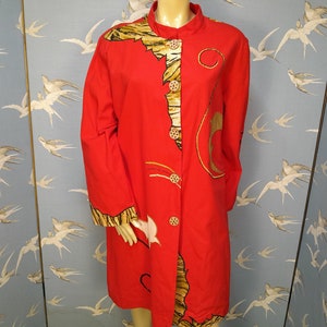 Op de afbeelding: Een lang rood knoopshirt met een tijgerprint en gouden accenten. Het shirt heeft een mandarijnskraag en lange mouwen.