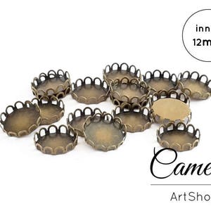 Può includere: Un set di 12 montature per cammei in metallo color ottone da 12 mm di diametro, con bordi a festoni. Le montature sono disposte a semicerchio su uno sfondo bianco. Il testo "inner 12mm" è visibile nell'angolo in alto a destra dell'immagine.