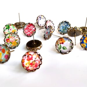 Puede incluir: Surtido de pendientes con estampado floral y engastes de bronce. Los pendientes tienen un borde festoneado y presentan una variedad de dise&ntilde;os florales en tonos azules, amarillos, rojos y verdes.
