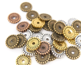 May include: A collection of decorative metal beads in various colors, including gold, bronze, copper, and silver. Each bead is round with a central hole and a detailed, sunburst-like pattern. Ideal for jewelry making and crafts.