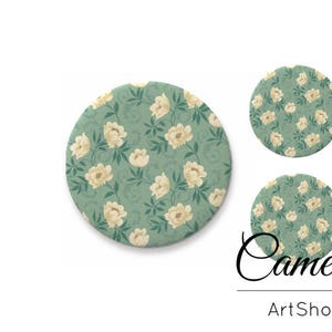 May include: Three round coasters with a floral pattern. The coasters feature a green background with white flowers and a delicate floral design. The coasters are labelled "Cameos ArtShop".
