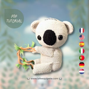 Peut inclure: Un koala en peluche crocheté tenant une branche avec des feuilles vertes. Le koala est assis sur un fond blanc avec un ciel bleu et des nuages. Le texte "PDF TUTORIAL" est dans un cercle au-dessus du koala. Le texte "La Fée Qui Pète" est en dessous du koala. Le texte "www.lafeequipete.com" est en dessous du koala. Il y a des drapeaux de France, des États-Unis, de l'Espagne, de l'Italie, du Portugal, de l'Allemagne et des Pays-Bas à droite du koala.