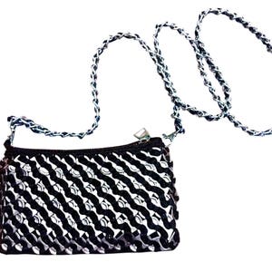 May include: A black and silver chain strap purse with a geometric pattern. The purse is made of a woven material and has a silver chain strap.