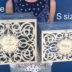 May include: Two decorative wedding card boxes, one labeled "Ali & Ayah" and the other "Harvey", in different sizes. The larger box is labeled "M size" and the smaller box is labeled "S size".