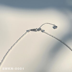 May include: A delicate silver necklace with a small heart charm and a beaded chain. The necklace is adjustable with an extender chain.