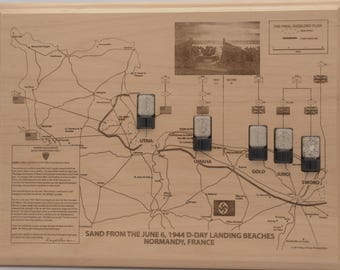 May include: A rectangular wooden plaque featuring an engraved map of Normandy, France, detailing the June 6, 1944 D-Day landing beaches. It includes five small, clear containers filled with sand from Utah, Omaha, Gold, Juno, and Sword beaches.