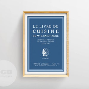 Puede incluir: Una impresión enmarcada de una portada de libro de cocina vintage en azul y blanco. El título dice "Le Livre de Cuisine de Me. Saint-Ange" con el texto "Recettes et methodes de la bonne cuisine francaise" debajo. La parte inferior de la impresión dice "Librairie Larousse - Paris (VI)"