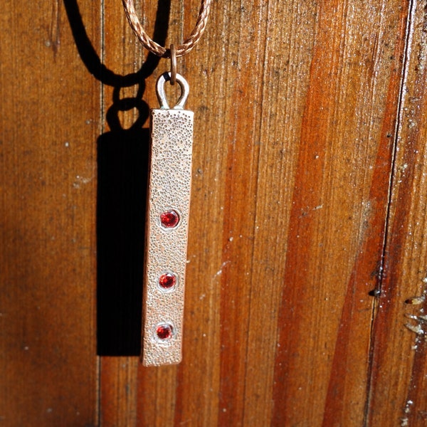 Pendentif en cuivre texturé fait à la main avec 3 pierres de corindon rouge <=> le prix comprend un collier + une pochette et la livraison