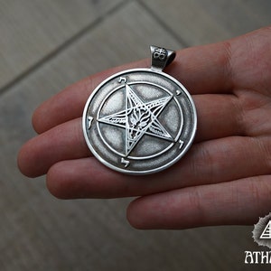 May include: Silver pendant featuring a pentagram with a goat's head inside. The pentagram is surrounded by a circle with the numbers 1-6 inscribed around it.