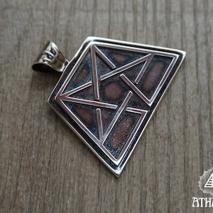 May include: A silver pendant with a geometric design. The pendant has a square shape with a complex pattern of lines and shapes in a darker, textured background. The bail is a simple loop for a chain.