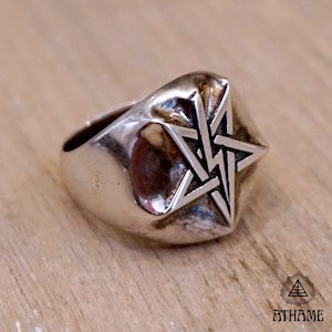 May include: A silver ring with a five-pointed star design. The star is made up of five interlocking triangles.