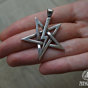 May include: A silver pendant in the shape of a five-pointed star with a complex, interwoven design. The star is a pentagram, a symbol with a long history of use in various cultures and religions.