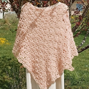 May include: A delicate, crocheted shawl in a soft pink color. The shawl is made with a lacy pattern and has a slightly scalloped edge.