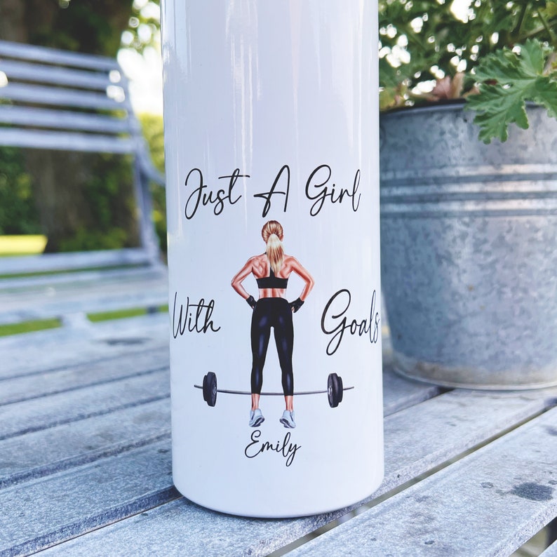 Op de afbeelding: Witte waterfles met een zwart-witte illustratie van een vrouw die gewichten heft. De tekst "Just a Girl with Goals" is boven de illustratie gedrukt en de naam "Emily" eronder.