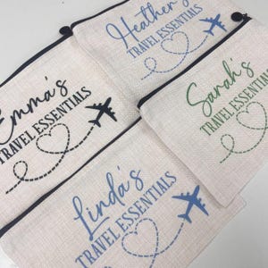 May include: Four personalized travel pouches with black, green, and blue accents. Each pouch features a name, the words "Travel Essentials", a heart with a dotted line, and an airplane.