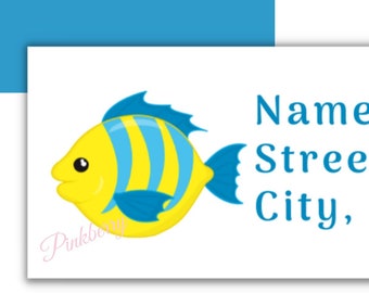 Può includere: Etichette per indirizzi con un'illustrazione di un pesce giallo e blu a cartoni animati. Le etichette includono il testo "Name Here, Street Address, City, State Zip". Lo sfondo è bianco e blu.