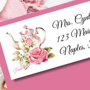 Puede incluir: Etiqueta de dirección blanca con una ilustración de tetera rosa y rosas. El texto en la etiqueta dice "Mrs. Cynthia Smith, 123 Main Street, Naples, FL 34102".