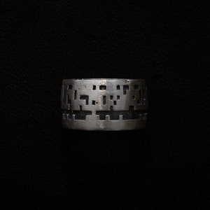 May include: A silver ring with a geometric design. The ring is made of metal and has a smooth finish.